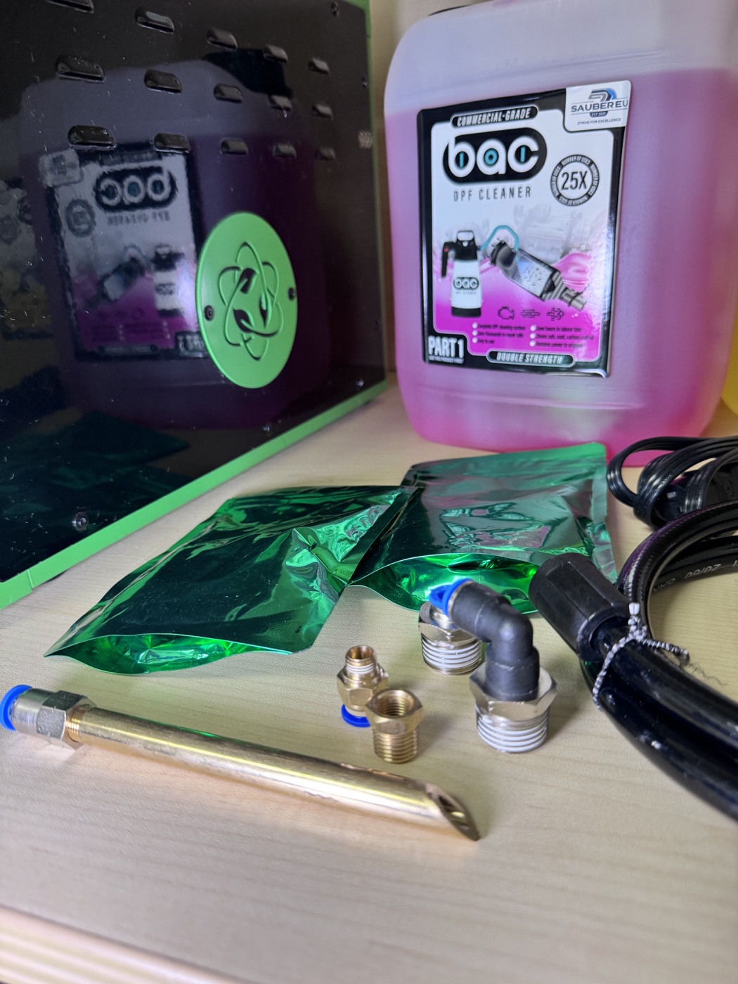 Accesorios, conexiones y producto de limpieza junto al equipo